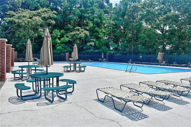 pool featuring fence and a patio