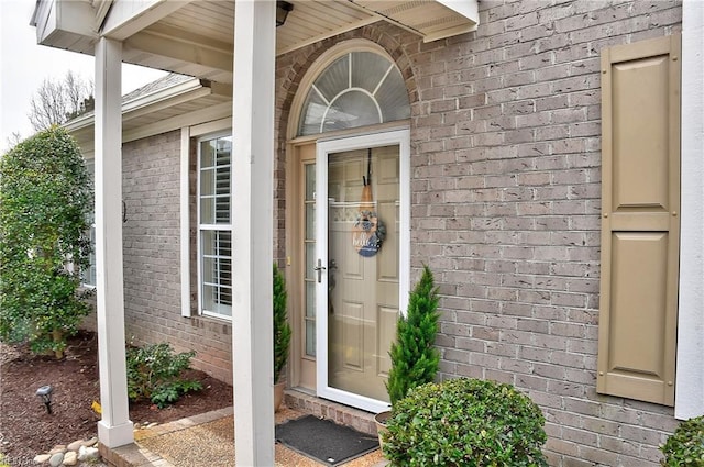 entrance to property featuring brick siding