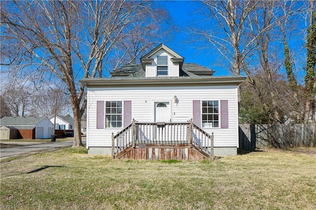 view of front of home with a front yard and fence