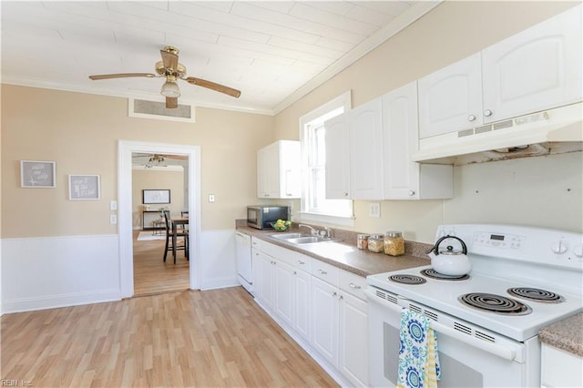 kitchen with crown molding, visible vents, a sink, white appliances, and under cabinet range hood