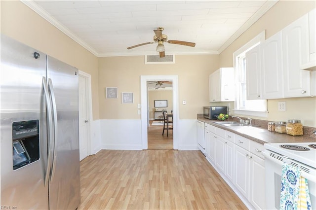 kitchen featuring white cabinets, appliances with stainless steel finishes, light wood-style flooring, and crown molding