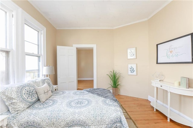 bedroom with wood finished floors and crown molding