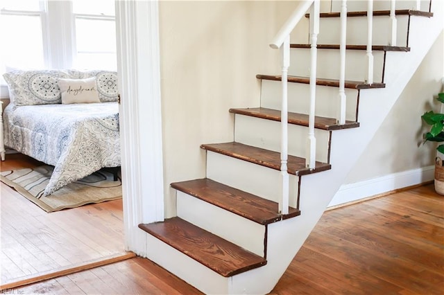 stairway with wood finished floors and baseboards