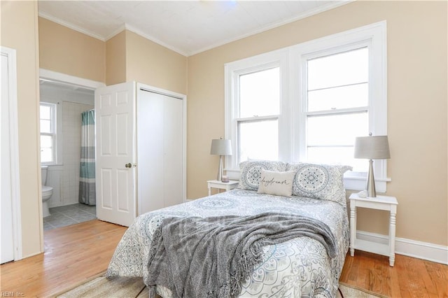 bedroom with ornamental molding, a closet, multiple windows, and wood finished floors