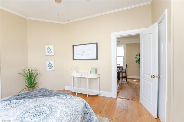 bedroom with light wood-style flooring, baseboards, and crown molding