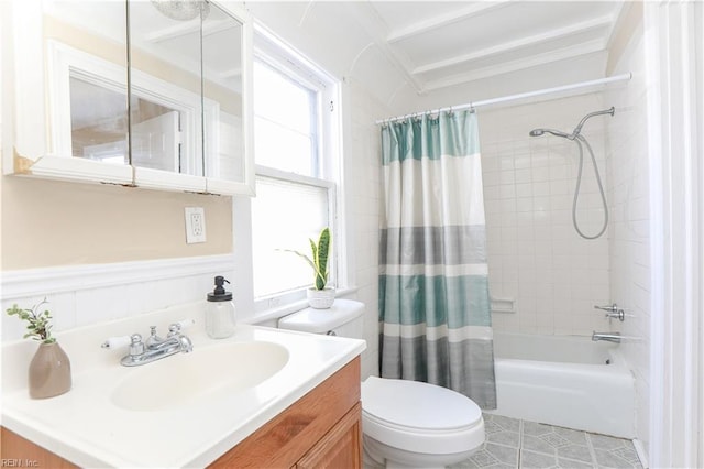 full bathroom with wainscoting, shower / bathtub combination with curtain, toilet, and vanity