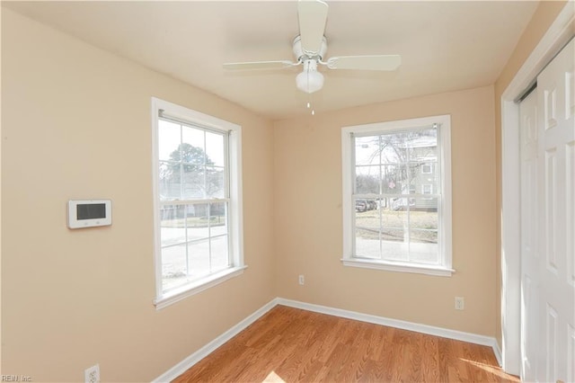 empty room with light wood-style flooring, baseboards, and a wealth of natural light