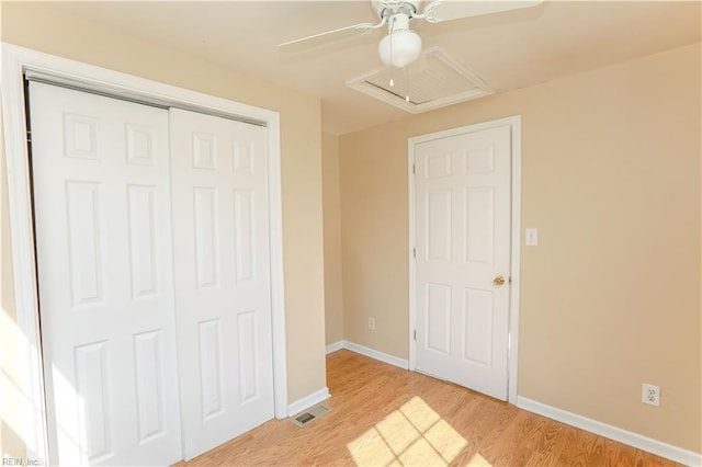 unfurnished bedroom with baseboards, visible vents, light wood-style flooring, ceiling fan, and a closet