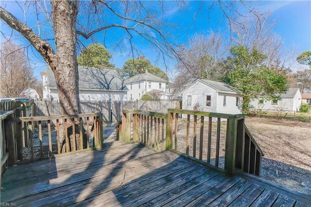 deck with an outdoor structure, a fenced backyard, and a residential view