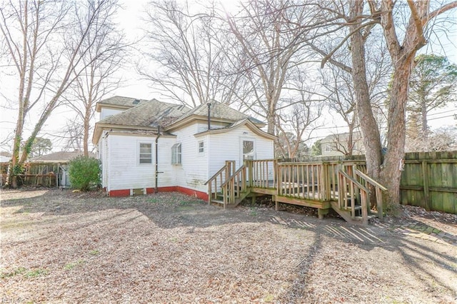 rear view of property with fence and a deck