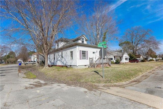 view of side of home with crawl space and a lawn