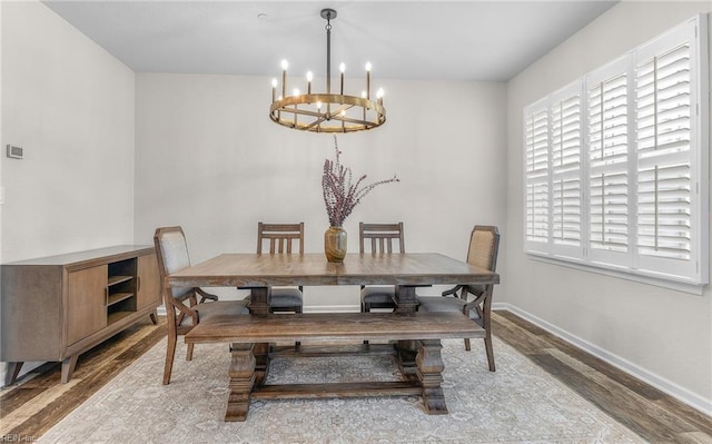 dining room with an inviting chandelier, baseboards, and wood finished floors