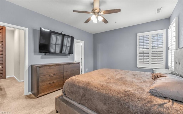 bedroom featuring light carpet, visible vents, baseboards, and a ceiling fan