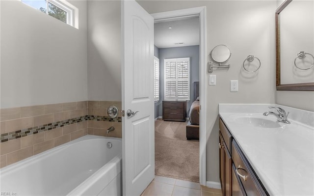 ensuite bathroom with a garden tub, tile patterned flooring, connected bathroom, and vanity