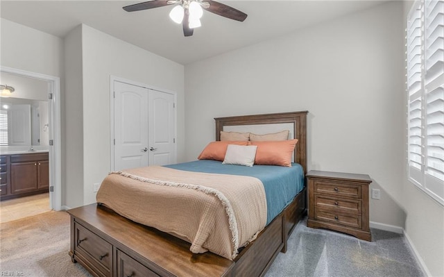 bedroom featuring ceiling fan, light carpet, a sink, baseboards, and a closet