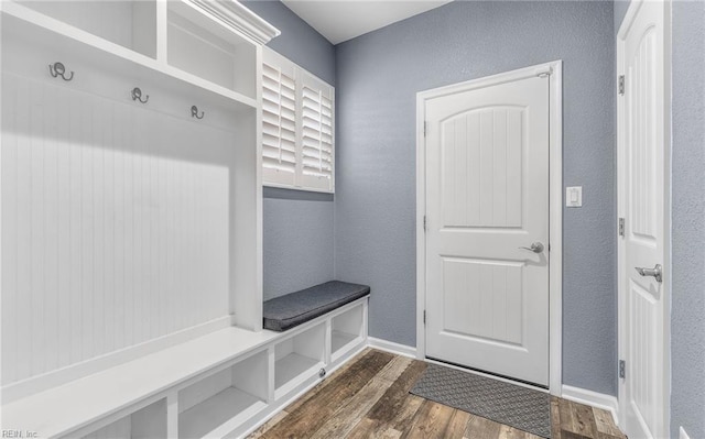 mudroom with baseboards, dark wood-style flooring, and a textured wall