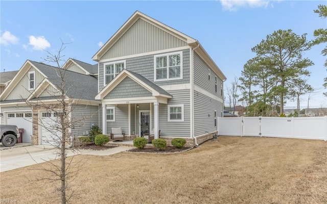 view of front of property featuring driveway, covered porch, a gate, fence, and a front lawn