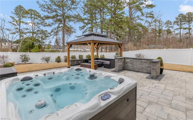 view of patio / terrace featuring a gazebo, a fenced backyard, an outdoor living space, and a hot tub