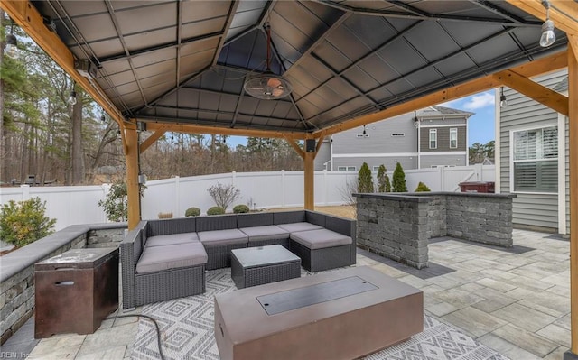 view of patio / terrace featuring a fenced backyard, an outdoor living space, and a gazebo