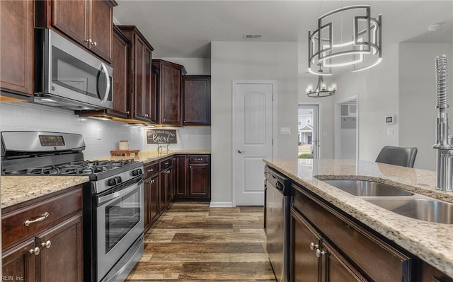 kitchen with visible vents, appliances with stainless steel finishes, dark wood finished floors, and light stone counters