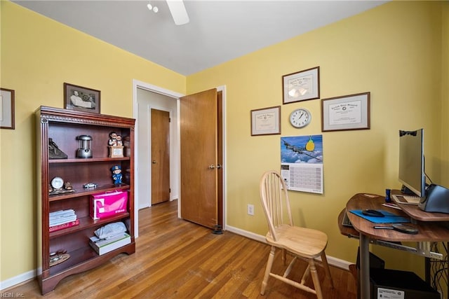 home office featuring wood finished floors, a ceiling fan, and baseboards