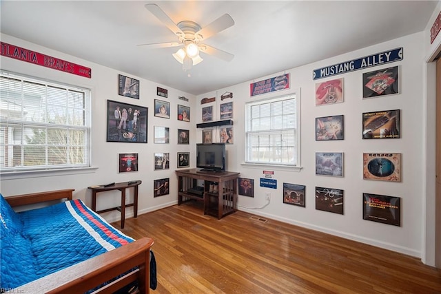 bedroom featuring visible vents, ceiling fan, baseboards, and wood finished floors