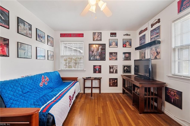 interior space featuring ceiling fan, baseboards, and wood finished floors