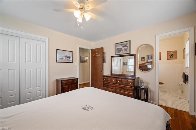 bedroom with dark wood-style floors, a closet, ensuite bath, and a ceiling fan