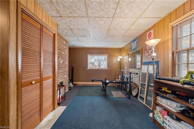 exercise area with carpet floors and wood walls