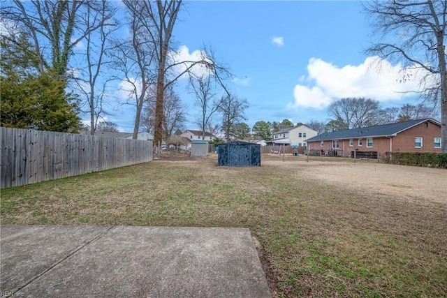 view of yard with a storage shed, fence, and an outdoor structure