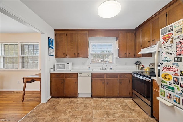 kitchen with white appliances, light countertops, a sink, and under cabinet range hood