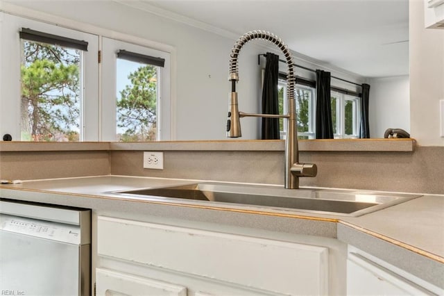 room details with white cabinets, dishwasher, light countertops, crown molding, and a sink