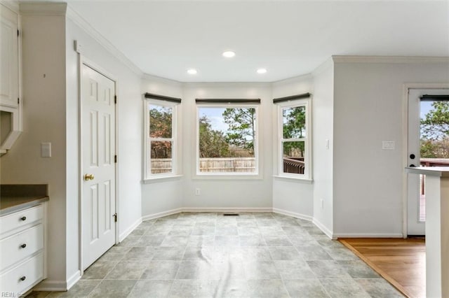 unfurnished dining area featuring baseboards, recessed lighting, and crown molding