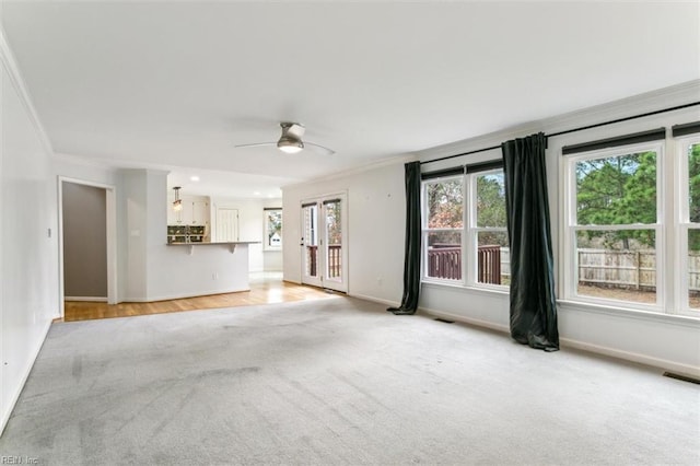 unfurnished living room featuring baseboards, crown molding, and light colored carpet