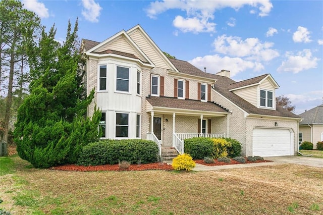 view of front of house featuring brick siding, a chimney, covered porch, a front yard, and driveway