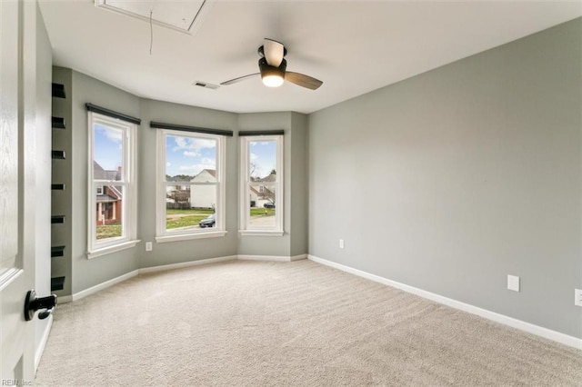 unfurnished room with visible vents, carpet floors, attic access, and baseboards