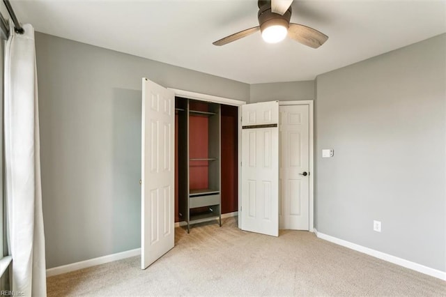 unfurnished bedroom featuring ceiling fan, baseboards, a closet, and light colored carpet