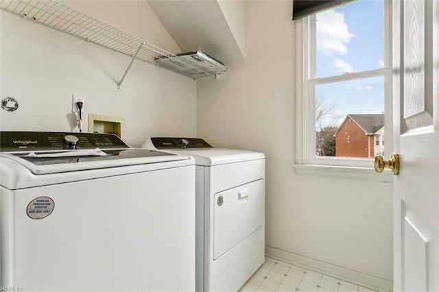 clothes washing area with washing machine and dryer, laundry area, baseboards, and light floors