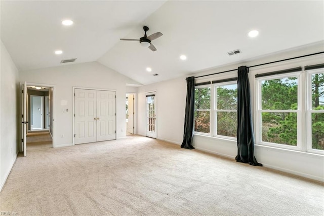 unfurnished bedroom with lofted ceiling, visible vents, light carpet, and baseboards