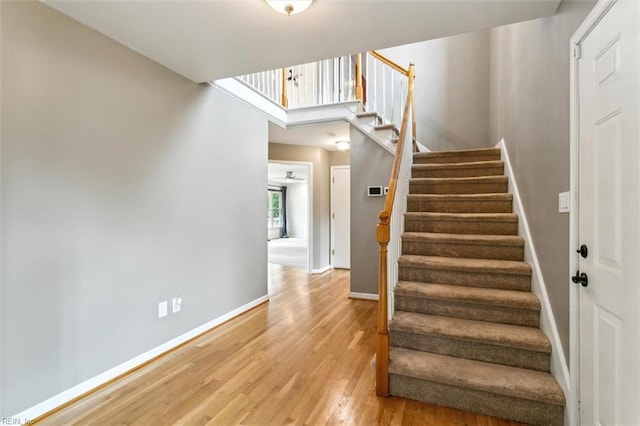 stairs with baseboards and wood finished floors