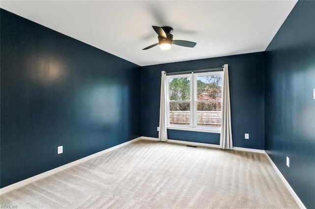 unfurnished room with ceiling fan, carpet, visible vents, and baseboards