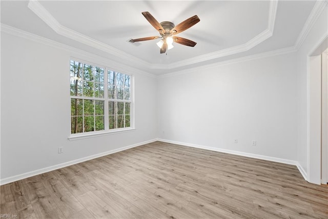 empty room with visible vents, ornamental molding, a ceiling fan, wood finished floors, and baseboards