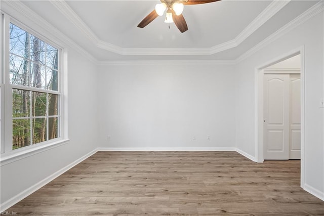 spare room with crown molding, baseboards, ceiling fan, and wood finished floors