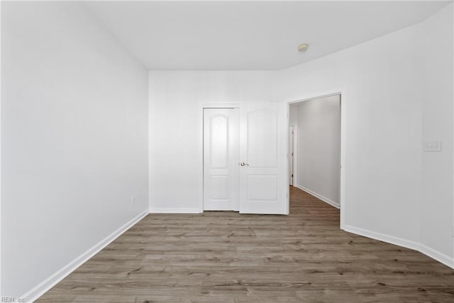 unfurnished room with wood finished floors and baseboards