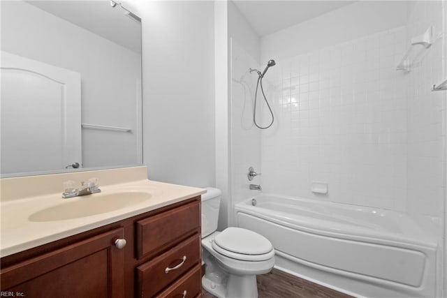 bathroom with toilet, bathtub / shower combination, wood finished floors, and vanity