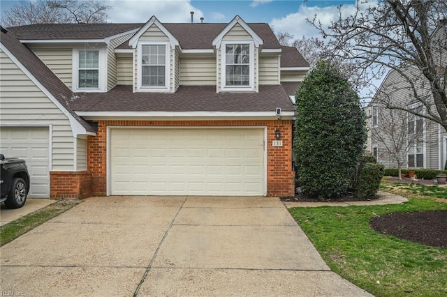 view of front of property with driveway, brick siding, and roof with shingles