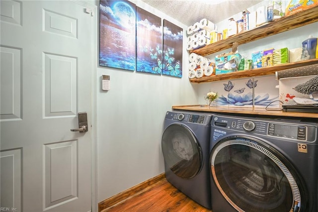 laundry room with laundry area, separate washer and dryer, and wood finished floors