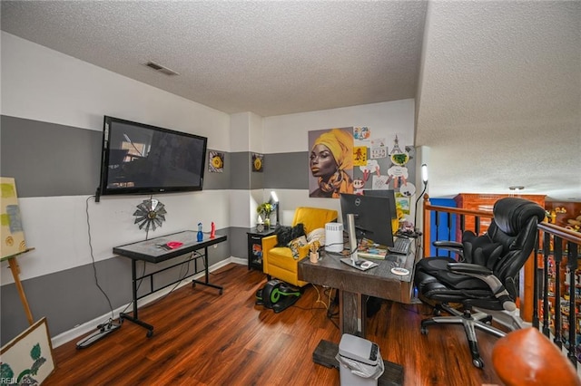 office featuring visible vents, a textured ceiling, baseboards, and wood finished floors