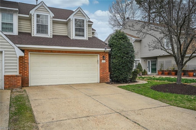 view of front of house featuring concrete driveway, brick siding, and a shingled roof