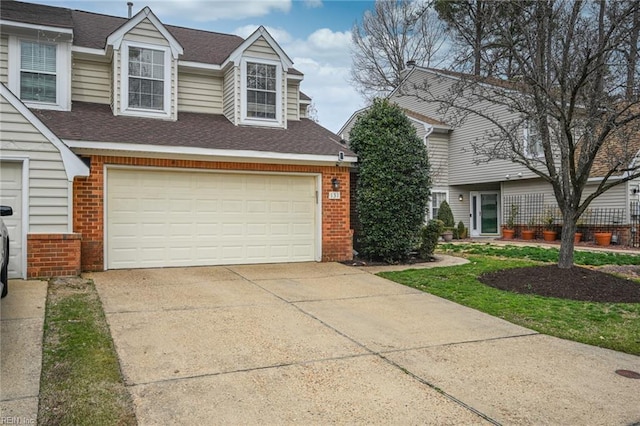 view of front of home with roof with shingles, concrete driveway, and brick siding